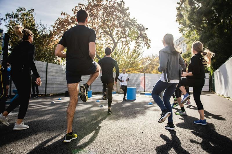 A group of energetic people participating in an outdoor fitness class to boost their vitality and improve their lifestyle.