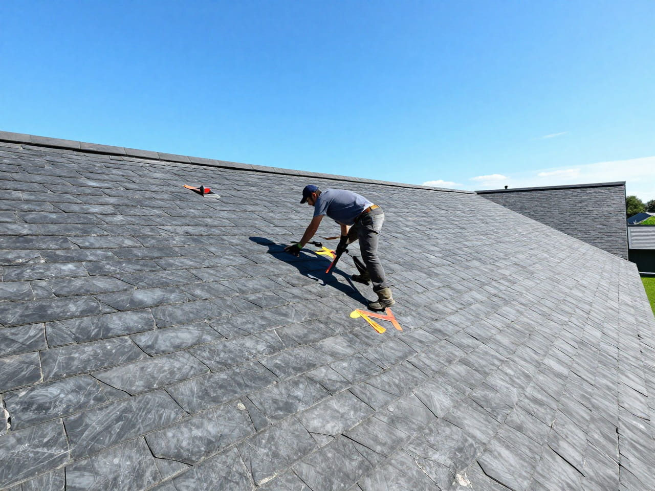 A City2Surf technician inspects an ageing slate roof, marking specific tiles with orange tape for repair.