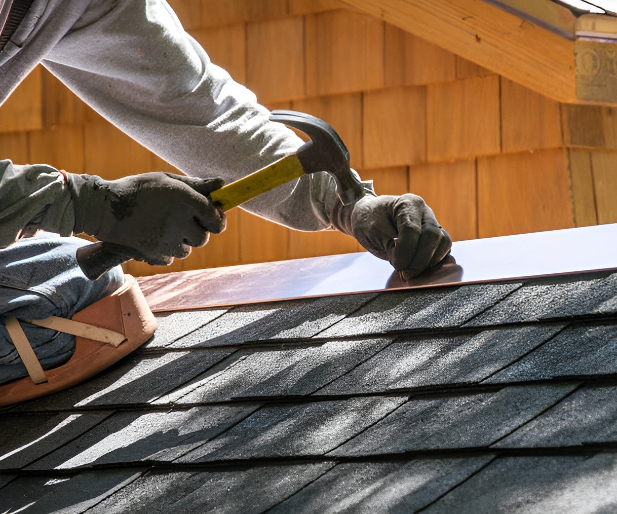 A roofer uses a hammer to secure copper flashing for City2Surf Sydney roof repair and replacement services.