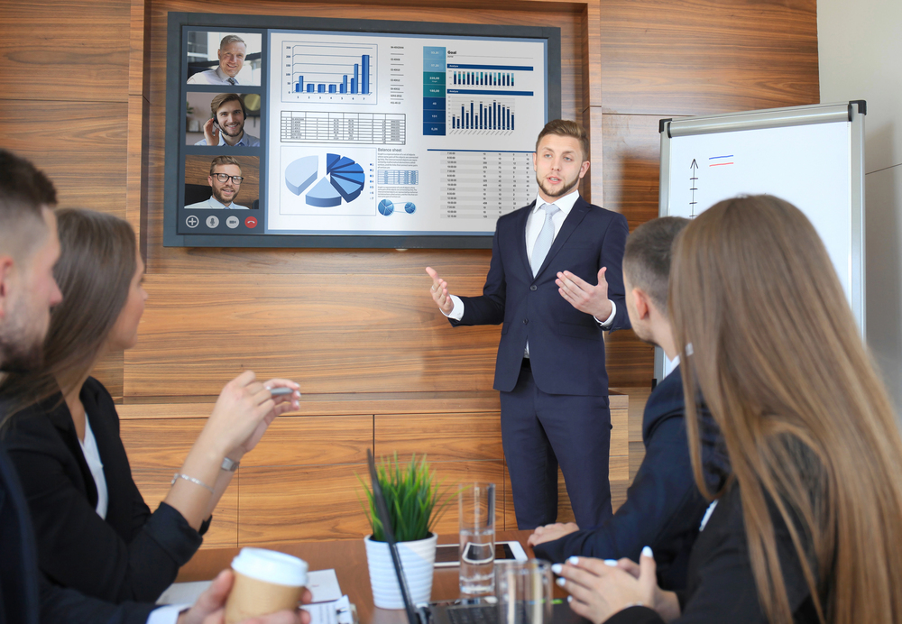 Business professional presenting financial charts to colleagues in a meeting